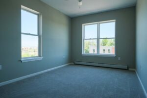 Bedroom with carpet and two windows at Cottonwood Crossing