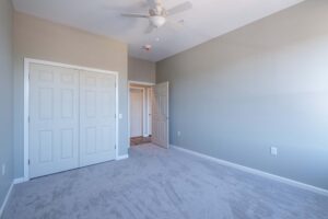 Bedroom with double doors and carpet at Cottonwood Crossing