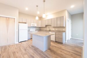 Cottonwood Crossing kitchen with grey cabinets and white appliances