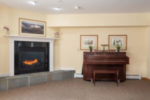 Gas fireplace and piano at Pinecrest Senior Living dining room