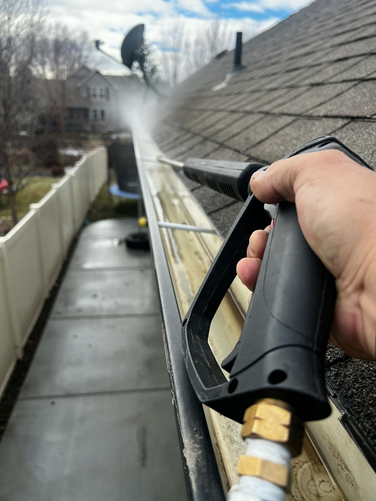 Pressure washing gutters during spring property maintenance in Vermont
